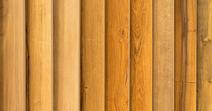 Nine wooden panels in various warm tones and textures are arranged in a slightly fanned, layered formation.