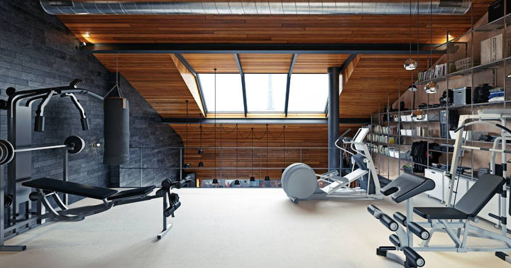 A punching bag and gym equipment sit beneath a curved wooden ceiling with a skylight and overhead lighting.